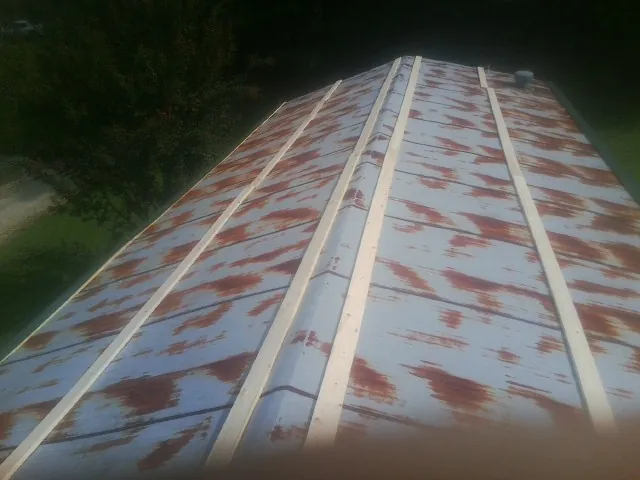 Rusted metal roof panels with new wood purlins before replacement — Storm Damage Roof Repair in Geff by Roofing Brothers