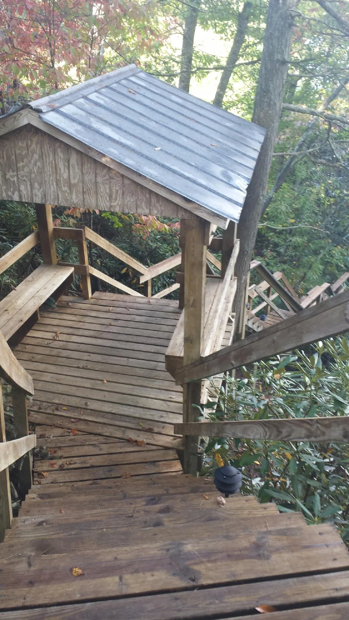 Metal roofed shelter over wooden steps on a wooded walkway — Skylight Repair & Installation work by our crew in Geff